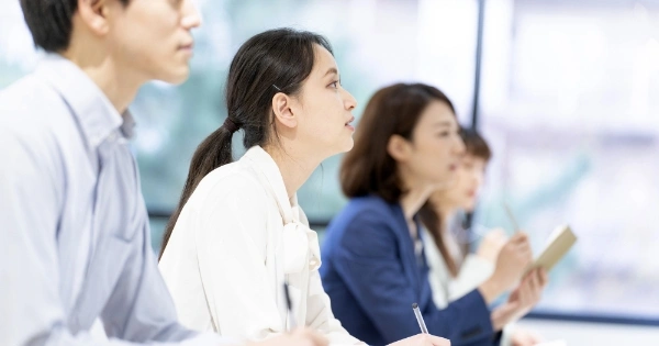 真剣に話を聞きながらノートを取っている4名の男女